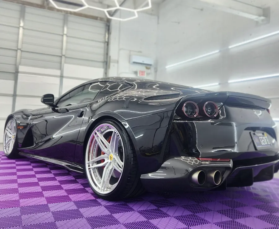Grey Ferrari 812 in the shop on purple tile floor