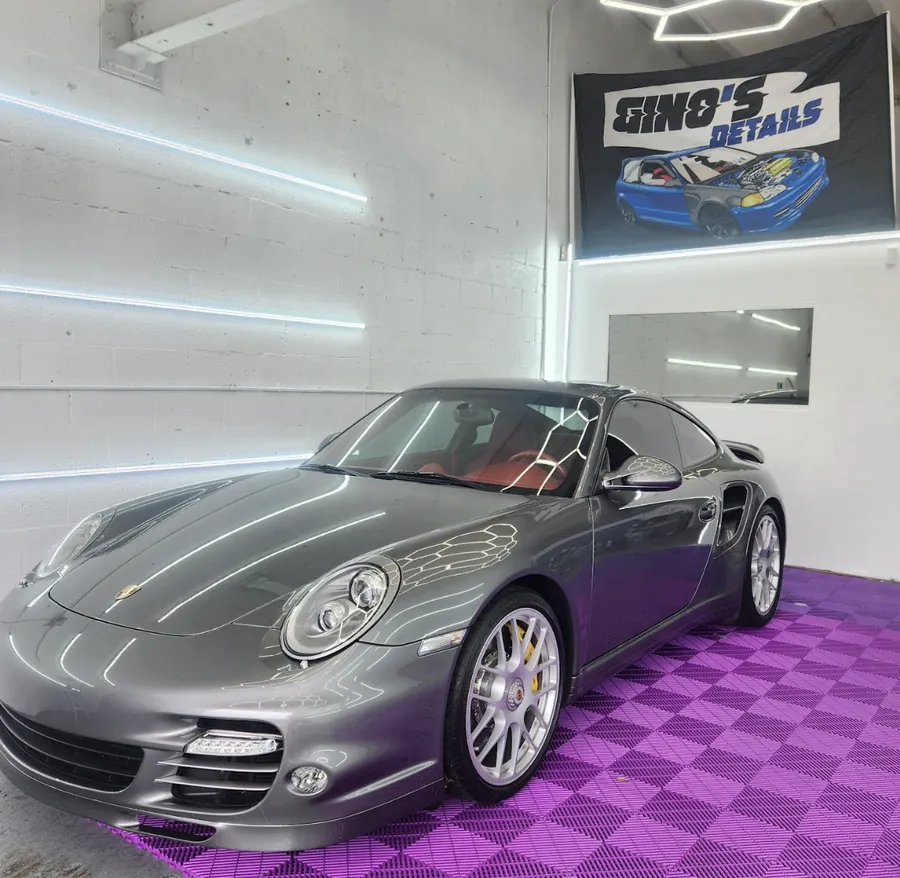 Grey Porsche 911 Turbo in the shop under hex lights