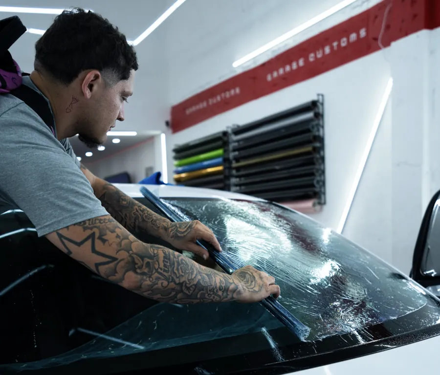 Installer laying film on a windshield